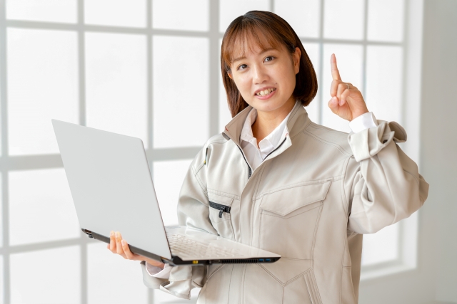 パソコンを持って指を指す女性警備員